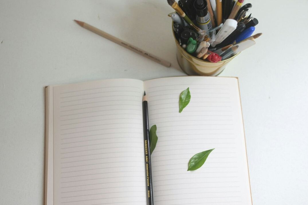 Open notebook with handwritten notes and a pen