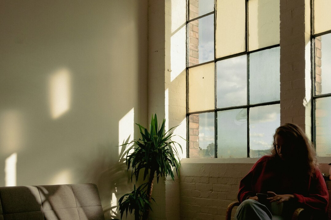Person sitting quietly reading by a window
